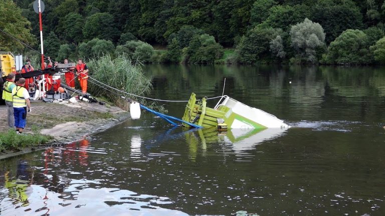 Tractor en balenpers missen het veer en rijden de Neckar in.