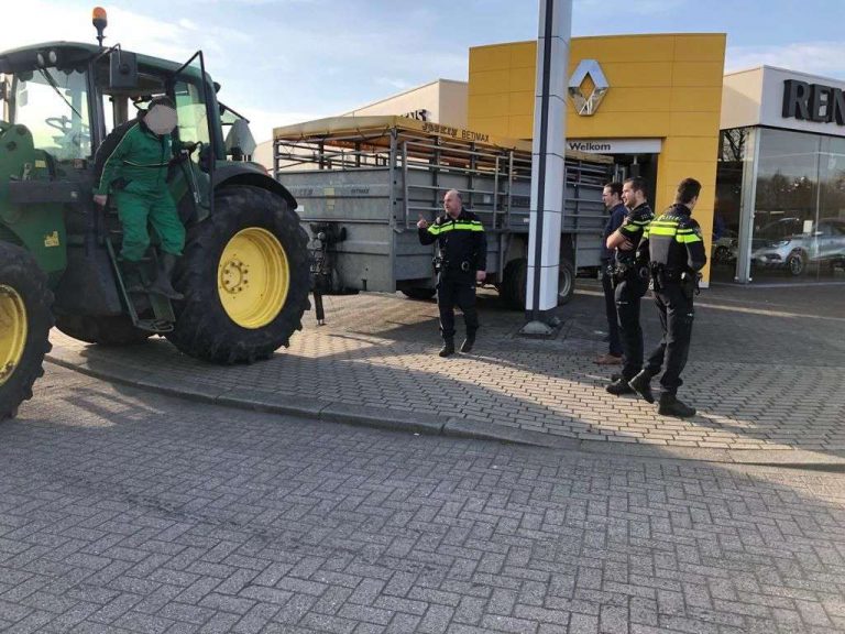 Boze veehouder zet veewagen voor ingang van autogarage