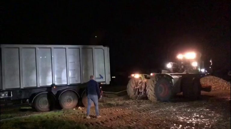 Vrachtwagen geladen me bieten glijdt van de weg Claas Xerion begint aan de klus..