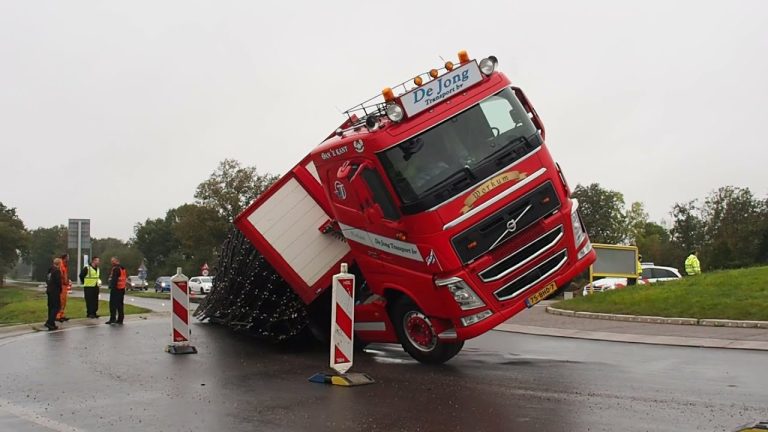Spanband geknapt, vrachtwagen kantelt op de rotonde